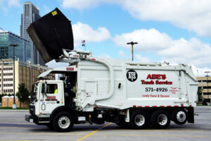 An Abe's Trash Service, Inc. truck with its compactor open, ready for junk removal in Omaha, NE.