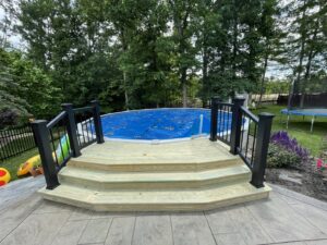 A custom-built wooden deck with steps leading to an above-ground pool by Inspired Renovation & Hardscape's in Lorain, OH.