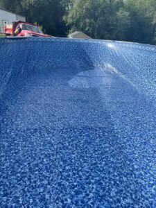 The blue liner of an above-ground pool being filled with water during installation by Advanced Pools and Repair, LLC in Bristol, CT.