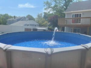 A sparkling above-ground pool featuring a decorative fountain, installed by Advanced Pools and Repair, LLC in Bristol, CT.