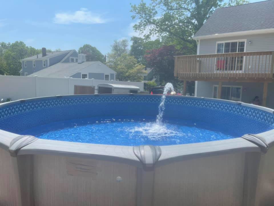 A sparkling above-ground pool featuring a decorative fountain, installed by Advanced Pools and Repair, LLC in Bristol, CT.