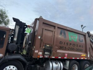 A large brown AC Disposal LLC junk removal truck with branding parked in San Antonio, TX.