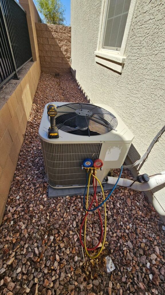 An outdoor AC unit undergoing repair or maintenance with tools and gauges by Medina's Handyman LLC in Las Vegas, NV