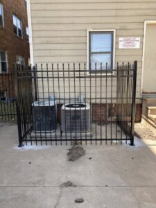 Outdoor AC units secured within a newly installed metal fence, a service provided by AON Handyman in Wichita, KS.
