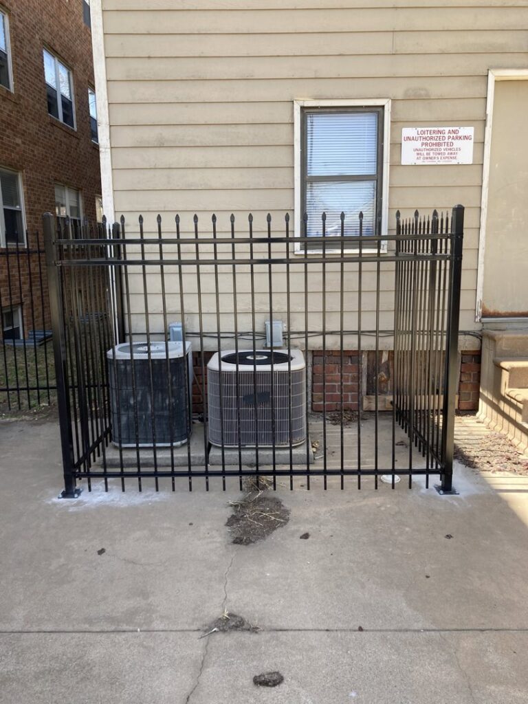 Outdoor AC units secured within a newly installed metal fence, a service provided by AON Handyman in Wichita, KS.