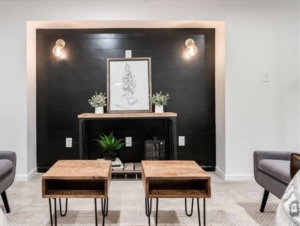 A modern accent wall featuring black shiplap paneling and sconce lighting, designed and installed by Dogwood Renovation & Design, LLC in Kansas City, MO.