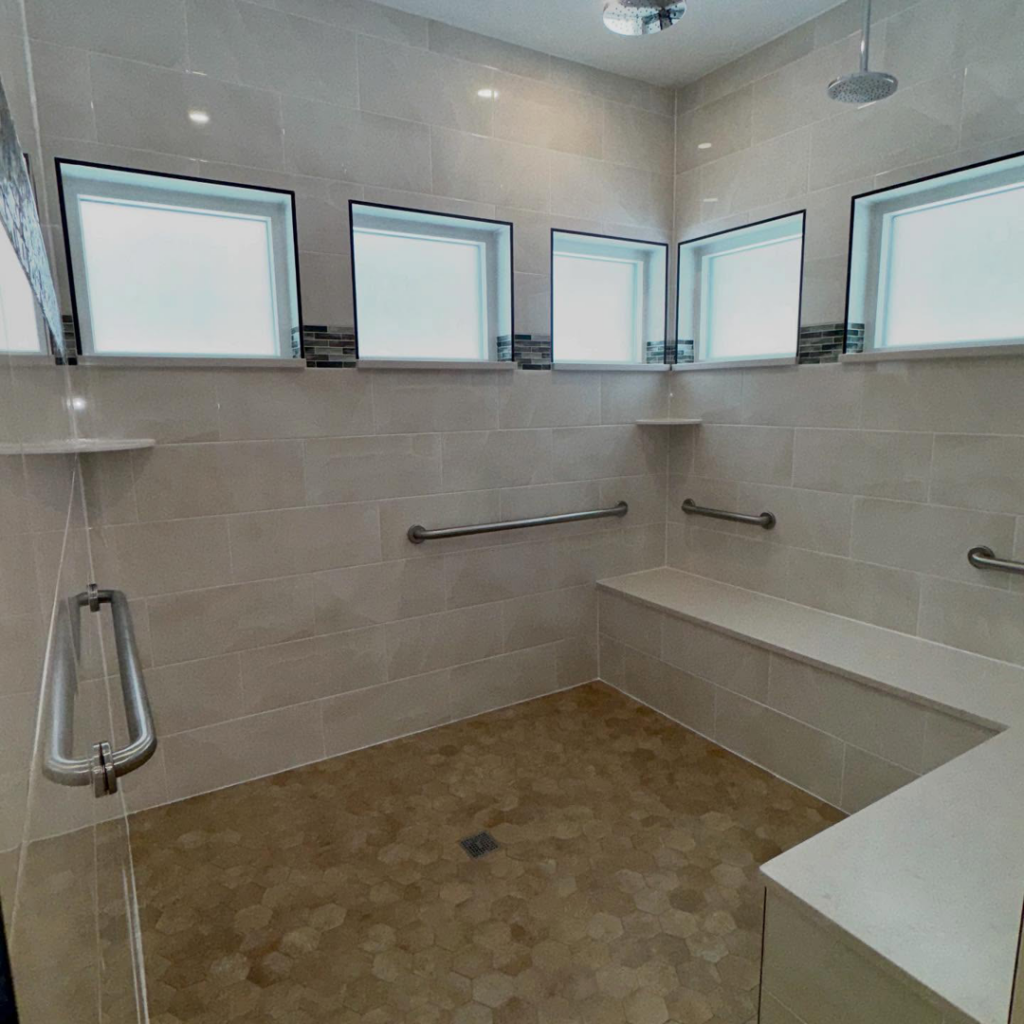 A newly installed accessible bathroom shower with modern tiles and grab bars by Mason Sky Enterprises in Worcester, MA.