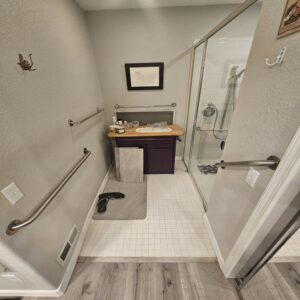 An accessible bathroom featuring a walk-in shower and grab bars, renovated by Jedi Bldrs in Colorado Springs, CO.