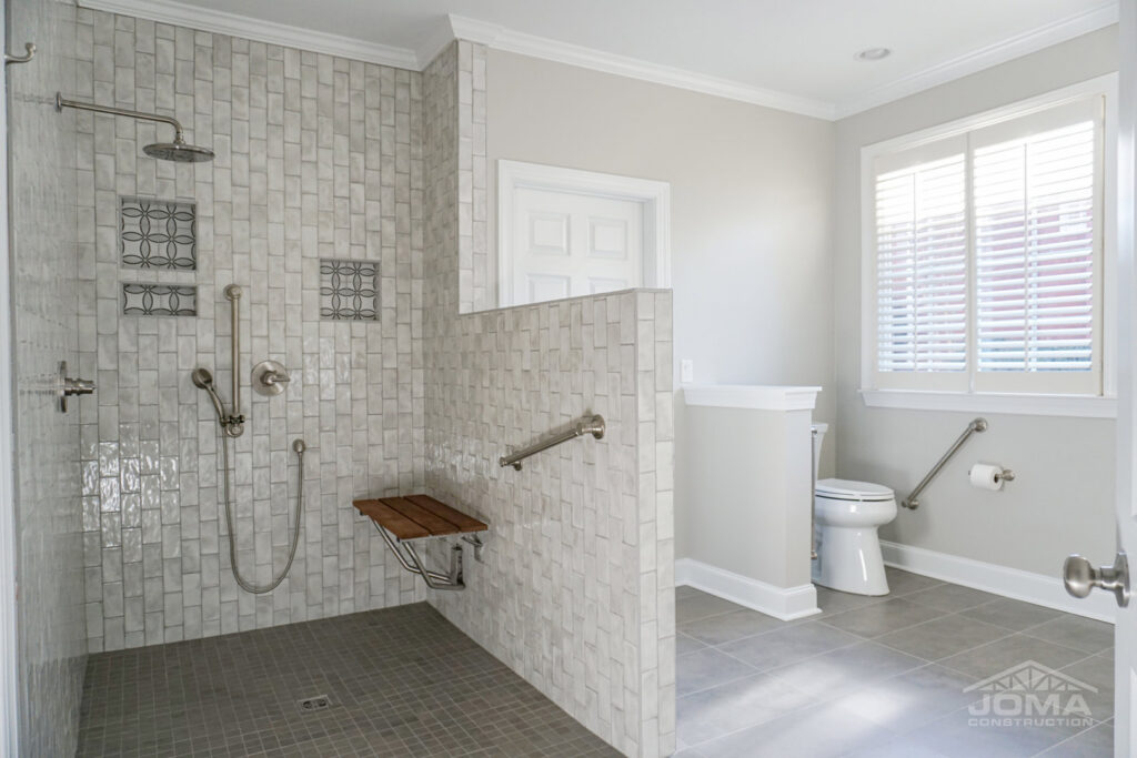 An accessible shower installation with grab bars and a folding seat by JOMA Construction in Athens, GA.