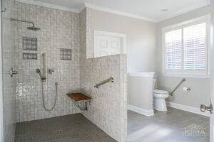 An accessible shower installation with grab bars and a folding seat by JOMA Construction in Athens, GA.