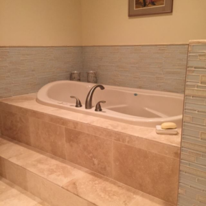 An accessible tiled shower with a grab bar and fold-down seat, expertly installed by Holland Construction LLC in Tucson, AZ.