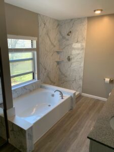 An accessible walk-in shower installation with grab bars and a built-in bench by Bath Planet of STL & More in Saint Charles, MO.
