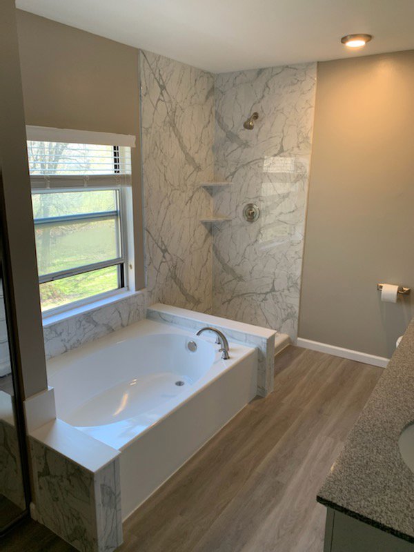 An accessible walk-in shower installation with grab bars and a built-in bench by Bath Planet of STL & More in Saint Charles, MO.
