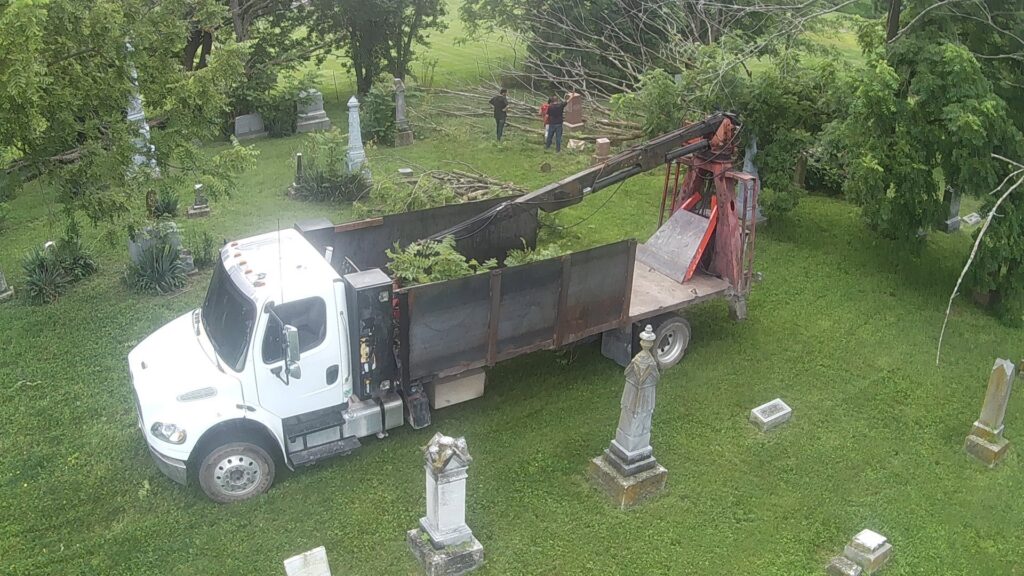 An aerial view of a grapple truck collecting tree debris in a cemetery, performed by Crockett's Tree Service in Lafayette, IN.