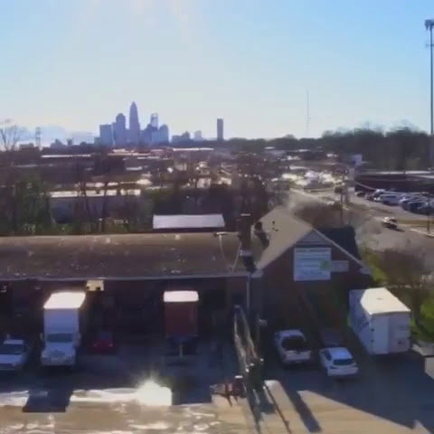 An aerial view of Queen City Metal Recycling & Salvage with the Charlotte, NC skyline in the background.