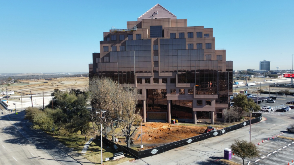 An aerial view of a commercial construction site with exposed dirt and equipment, managed by Tarrant Construction Services, LTD in Fort Worth, TX
