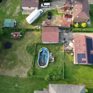 An aerial view of a house with a completed red roof and solar panel installation by GOAT Services, LLC in Louisville, KY.