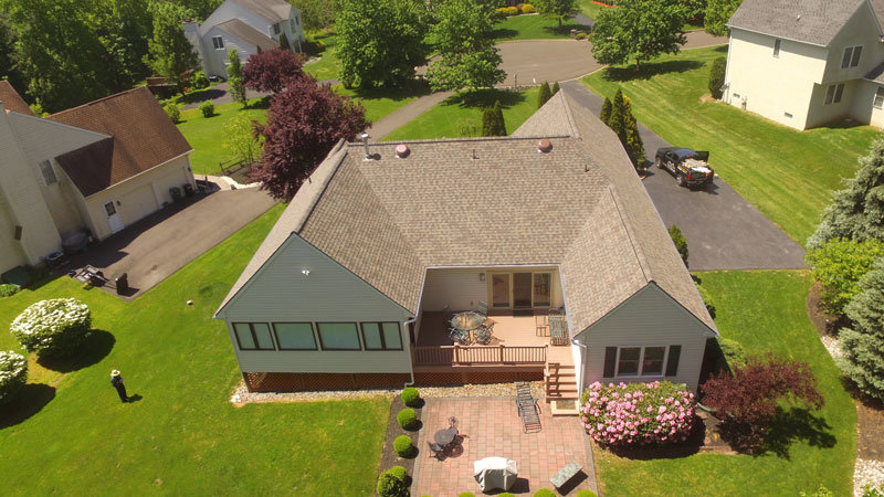 An aerial view of a residential property showcasing a newly installed roof and well-maintained landscaping by Glick's Exteriors in Philadelphia, PA.