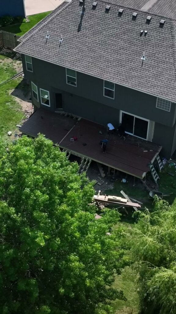 An aerial view of a deck under construction with workers on site by Deckscape KC in Kansas City, MO.