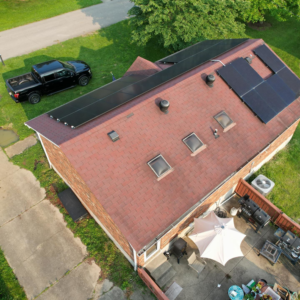 An aerial view of a house with a red shingle roof and newly installed solar panels by GOAT Services, LLC in Louisville, KY.