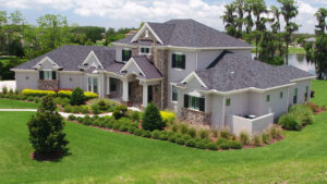 An aerial view of a large traditional home with a dark roof and lush landscaping, built by TamLin Homes Inc in Tampa, FL