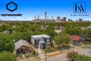 An aerial view of a modern home in San Antonio, TX, showcasing HomeNovate's construction with the city skyline in the background.