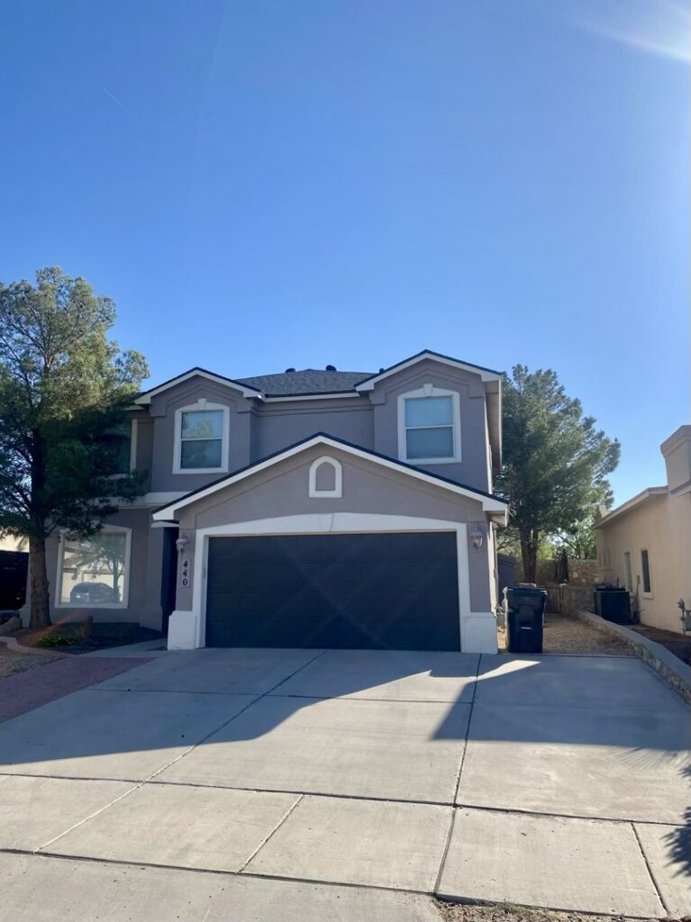 An aerial view of a residential house with a newly installed dark shingle roof and completed patio area by Masota Construction in El Paso, TX.