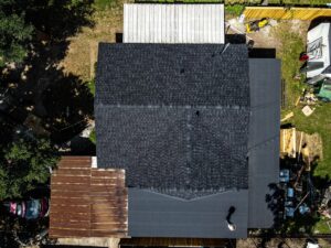 An aerial view of a residential property with a newly installed shingle roof by Riker Home Services in Plano, TX
