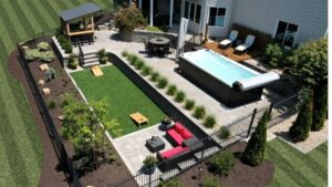 An aerial view of a luxurious outdoor kitchen, multiple patios, and swim spa area by Rescue Landscaping and Outdoor Living in St. Louis, MO