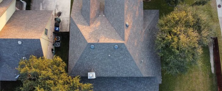 An aerial view showcasing a newly installed residential roof by Total Improvements LLC, a general contractor in San Antonio, TX.