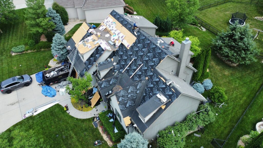 An aerial view of a house undergoing roof replacement with underlayment installed by Element Enterprises in Kansas City, MO.