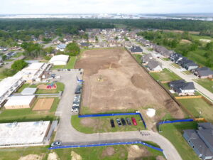 An aerial view of a site undergoing preparation next to a residential area and school, managed by Sendero Industries in Houston, TX.