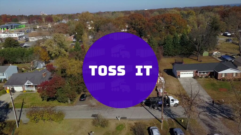 An aerial view showing a Toss-It truck and dumpster on a residential street, providing junk removal service in Baltimore, MD.