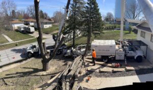 An aerial view of a tree removal site with cut logs, a wood chipper, and a bucket truck from Southern Accent Tree Service in West Des Moines, IA.