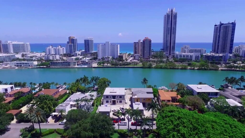 An aerial view of waterfront properties under construction with the Miami skyline in the background by Intelligent Construction Inc. in Miami, FL.