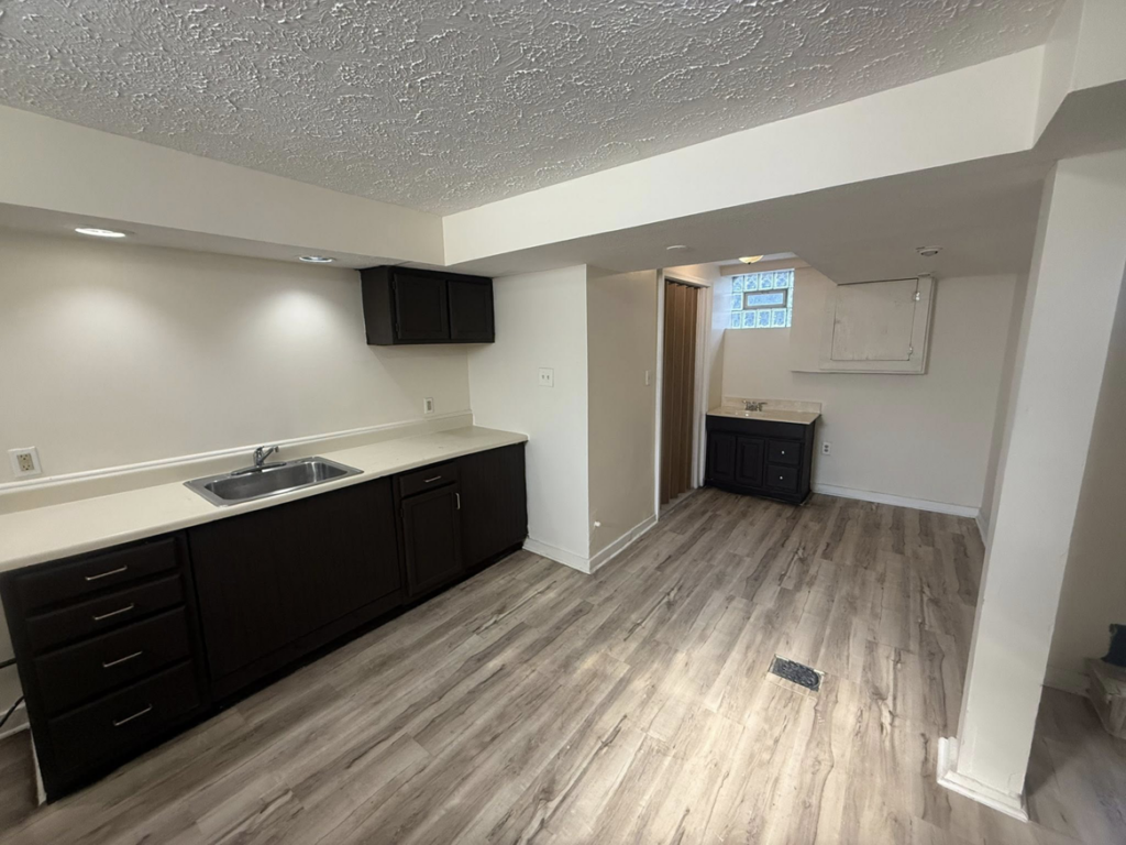 A beautifully renovated basement kitchen and bar area with new flooring and cabinets by Inside Out Commercial Solutions in Cleveland, OH.