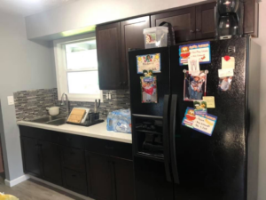 After kitchen remodel featuring new dark cabinets and mosaic backsplash by All in One Remodeling Services LLC in East Sandwich, MA