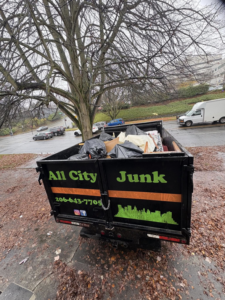 All City Junk Removal branded truck, loaded with debris and trash bags, parked on a street after a junk removal service in Kent, WA.