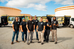 The Aloha Junk Man team standing proudly in front of their fleet of junk removal trucks in Kailua, HI.