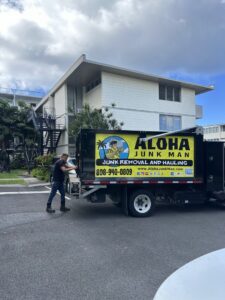 An Aloha Junk Man truck and a team member at a residential or commercial junk removal job site in Kailua, HI.