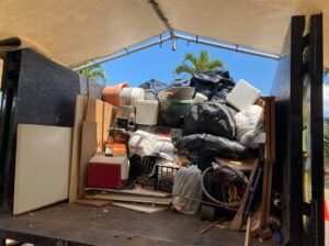 An Aloha Junk Man truck filled to the brim with a variety of mixed junk, debris, and household items in Kailua, HI.