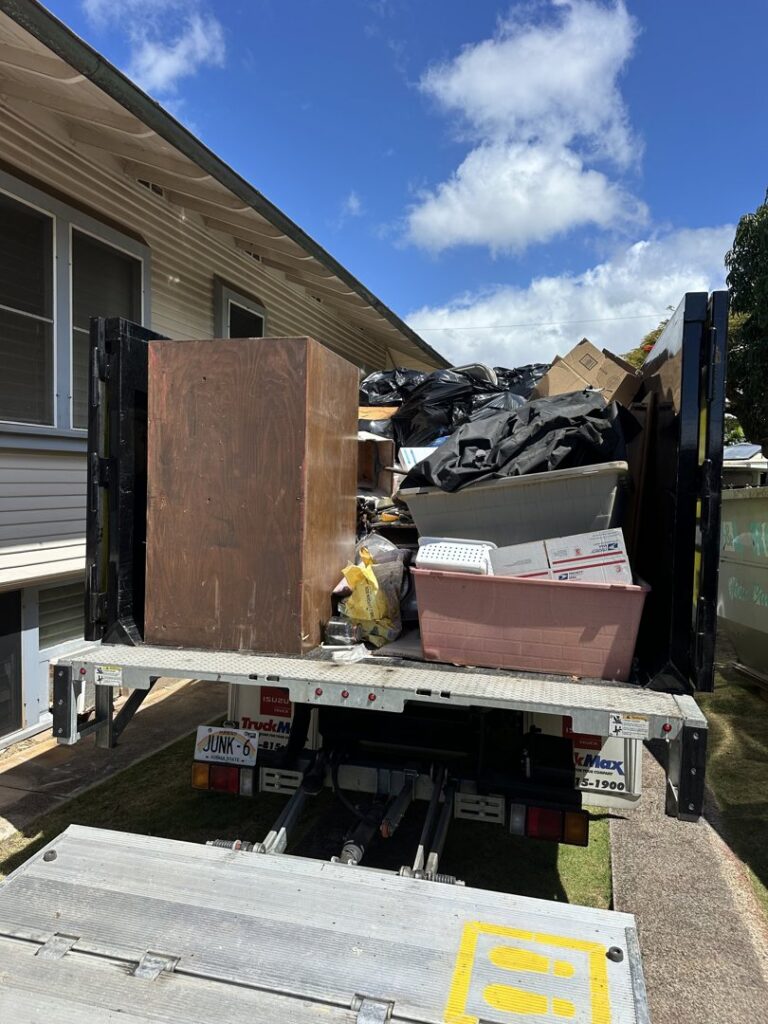 The back of an Aloha Junk Man truck fully loaded with furniture, bags, and other junk after a removal job in Kailua, HI.