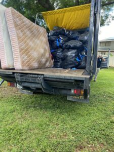 An Aloha Junk Man truck loaded with old mattresses and black trash bags after a successful junk removal service in Kailua, HI.