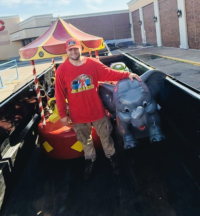 A Junk Haulin Heroes team member removing amusement rides from a truck bed in Bismarck, ND.