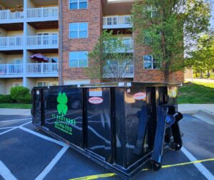 A KC Brothers Disposal dumpster parked in the lot of an apartment complex for waste management in Kansas City, MO.
