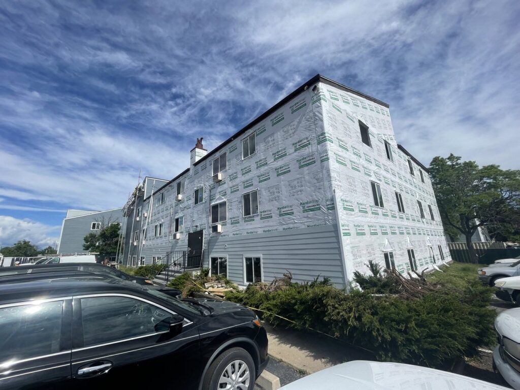 Apartment building with siding installation in progress by Colorado Window Solutions in Denver, CO.