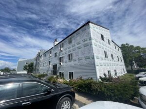 Apartment building with siding installation in progress by Colorado Window Solutions in Denver, CO.