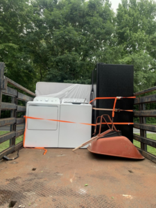 A truck loaded with a washer, dryer, refrigerator, and wheelbarrow for Allen's Junk Removal & Hauling in Smyrna, TN.