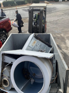 A forklift loading old appliances into a junk removal truck for Allen's Junk Removal & Hauling in Smyrna, TN.