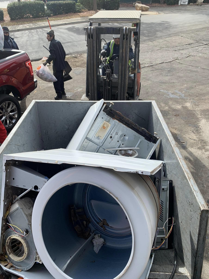 A forklift loading old appliances into a junk removal truck for Allen's Junk Removal & Hauling in Smyrna, TN.